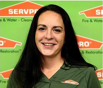 Female SERVPRO® Employee standing in front of SERVPRO logo