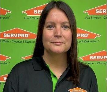 female SERVPRO employee in front of green backdrop